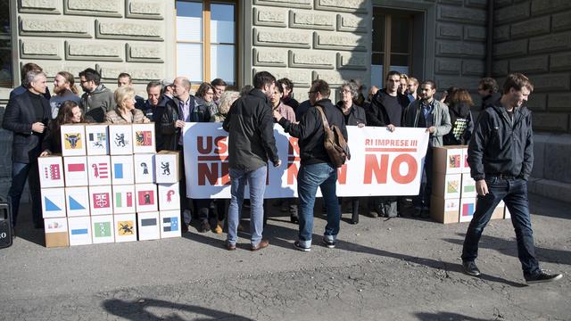 Le comité référendaire lors du dépôt des signatures à Berne. [Keystone - Peter Schneider]