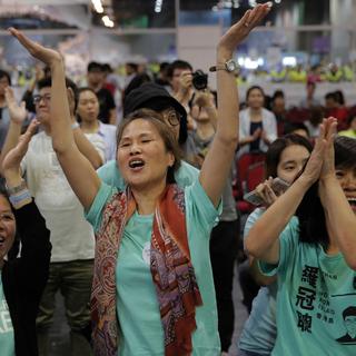 Des supporters du parti Demosisto célèbrent la victoire de Nathan Law, partisan de la rupture avec Pékin. [Keystone - Vincent Yu]