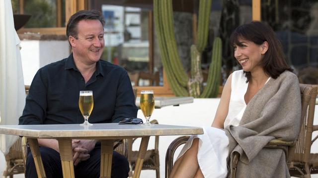 David Cameron, ici en compagnie de sa femme Samantha, affirme avoir vendu ces parts avant d'être élu Premier ministre. [Neil Hall/Pool Photo via AP]