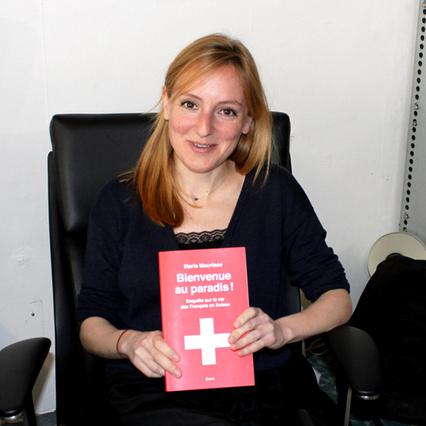 La journaliste Marie Maurisse pose avec son livre "Bienvenue au paradis!". [swissinfo.ch]