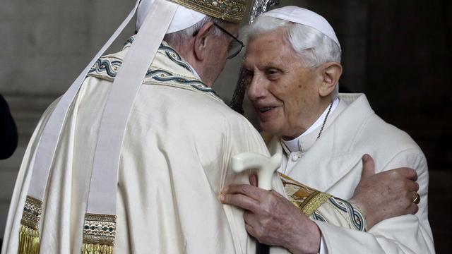 Le pape émérite Benoît XVI (à droite) salue le pape François dans la basilique St-Pierre. [Keystone - Gregorio Borgia]