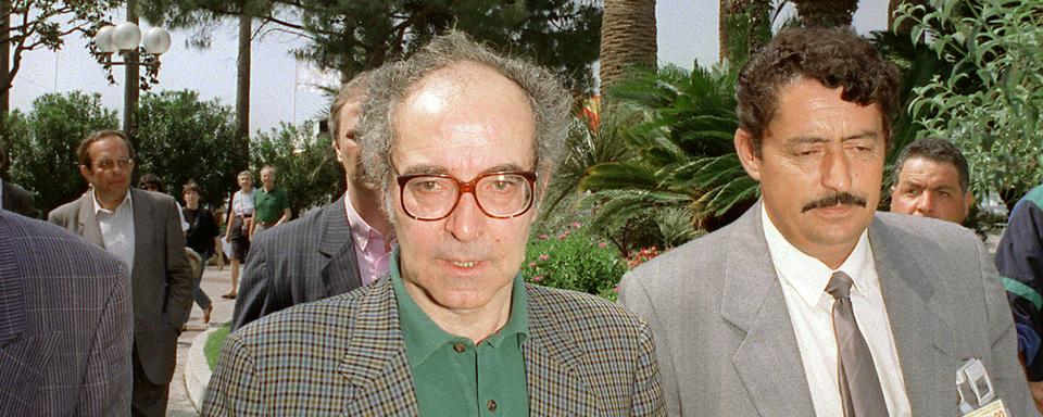 Le réalisateur suisse Jean-Luc Godard rejoint son hôtel sur la Croisette à Cannes, le 18 mai 1995, après la conférence de presse qu'il a donnée pour son film "Nouvelle vague" en compétition officielle. [AFP - Patrick Kovarik]