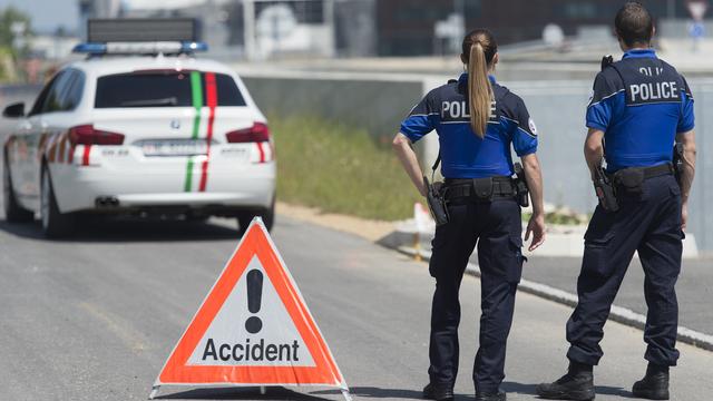 Deux membres de la police cantonale neuchâteloise sur les lieux d'un accident. [SANDRO CAMPARDO]