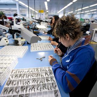 Une employée en train de travailler sur des prothèses auditives à Stäfa, dans le canton de Zurich.