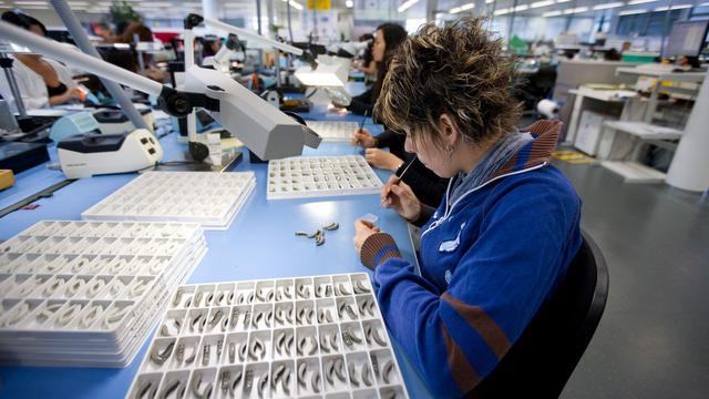 Une employée en train de travailler sur des prothèses auditives à Stäfa, dans le canton de Zurich.