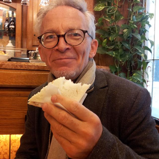 Laurent Cittone se délecte d'un tramezzini, petit sandwich vénitien au pain de mie et mayonnaise. [Antoine Lalanne-Desmet]