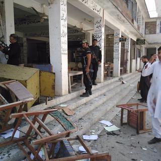 Des policiers inspectent les lieux de l'attaque, survenu vendredi. [AFP - A. Majeed]