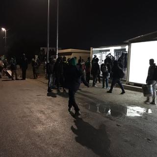 Au petit matin, des dizaines de migrants se sont retrouvés à l'entrée du camp pour commencer à évacuer. [RTS - Ariane Hasler]