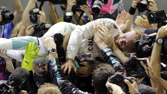 Nico Rosberg est félicité comme il se doit par son équipe après sa première victoire à Singapour. [Keystone - Wong Maye-E]