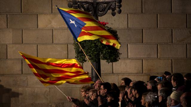 Des partisans de l'indépendance de la Catalogne agitent le drapeau catalan et la bannière pro-indépendance à Barcelone, en janvier.