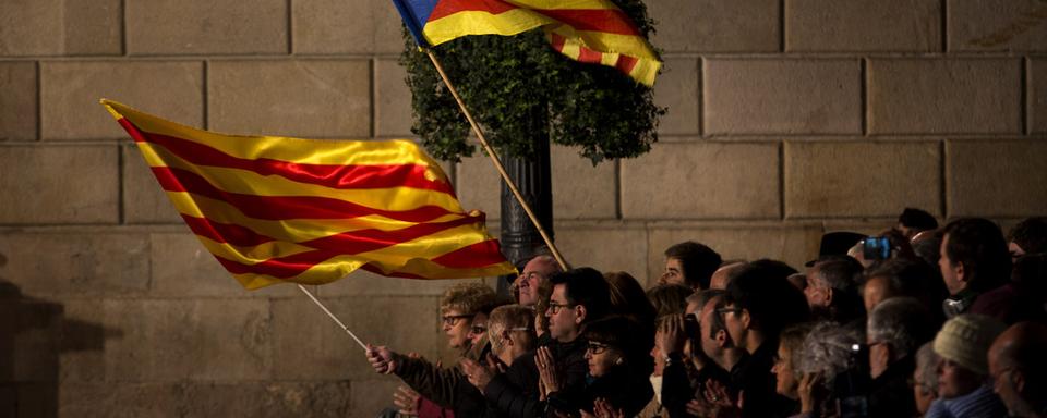 Des partisans de l'indépendance de la Catalogne agitent le drapeau catalan et la bannière pro-indépendance à Barcelone, en janvier.