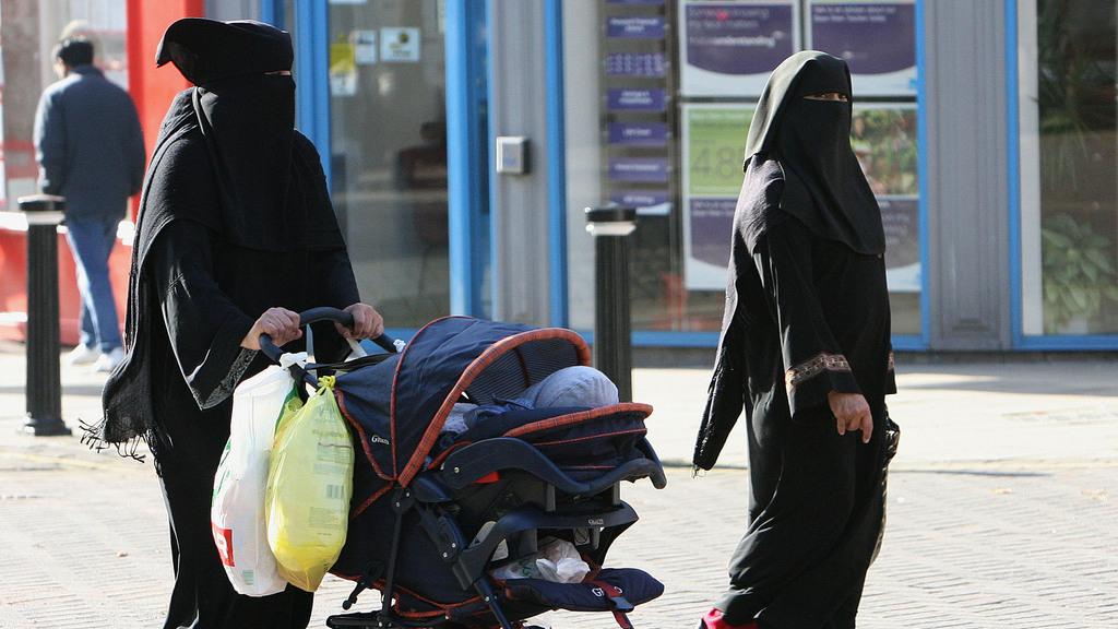Deux femmes de confession musulmane se promenant à Blackburn City, en Angleterre. [Keystone - Dave Thompson]