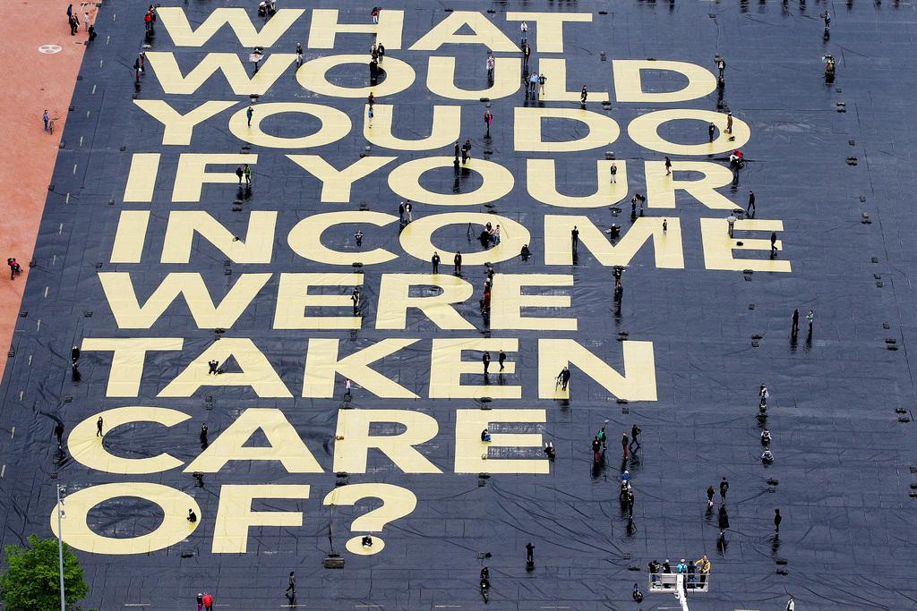 Sur l'affiche était écrite en anglais la question: "Quel travail ferais-tu si ton revenu était assuré ?" [Keystone]