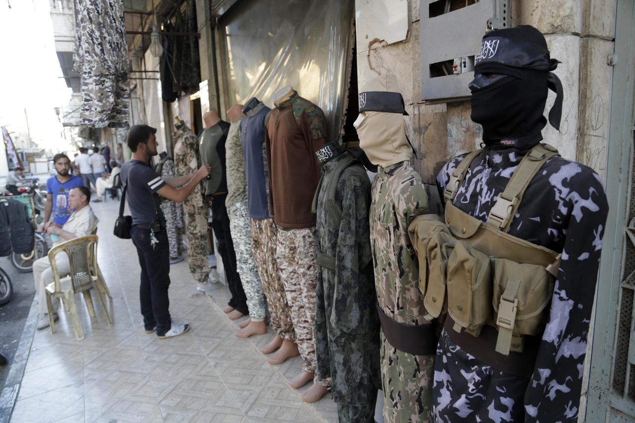 Un homme inspecte des vêtements militaires en vente au sud d'Idlib. [REUTERS - Khalil Ashawi]