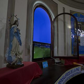Un match de foot montré dans une église madrilène. [Keystone - Paul White]