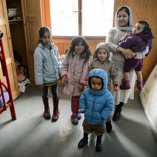 Des requérants d'asile posent dans une chambre d'un chalet de l'EVAM, février 2016. [Keystone - Jean-Christophe Bott]