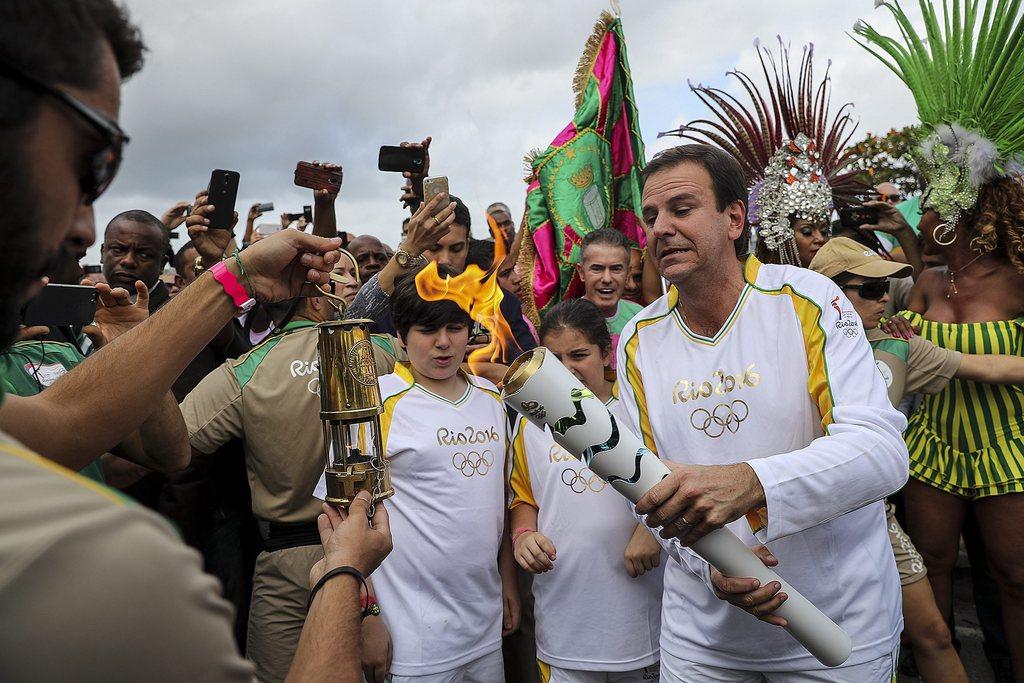 Le maire de Rio, Eduardo Paes, a reçu la flamme dans une petite lampe en laiton avant d'allumer la torche. [Keystone - Antonio Lacerda]