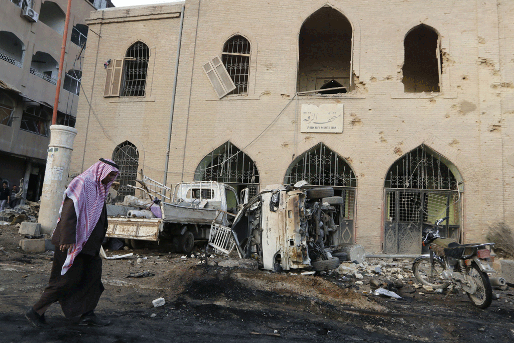 Un homme passe devant le musée de Raqqa, touché par des frappes aériennes. [Reuters - Nour Fourat]