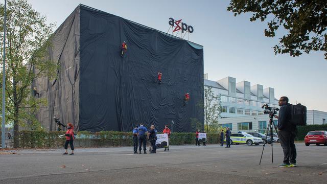 Les militants ont escaladé le siège d'Axpo et déroulé des bandes de tissu noir sur les façades du bâtiment. [Greenpeace Schweiz]