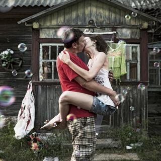Zhenya (Evgeny) et Yulia s'embrassent devant leur datcha pendant leur cérémonie de mariage. [Swiss Presse Photo / Keystone - Niels Ackermann]