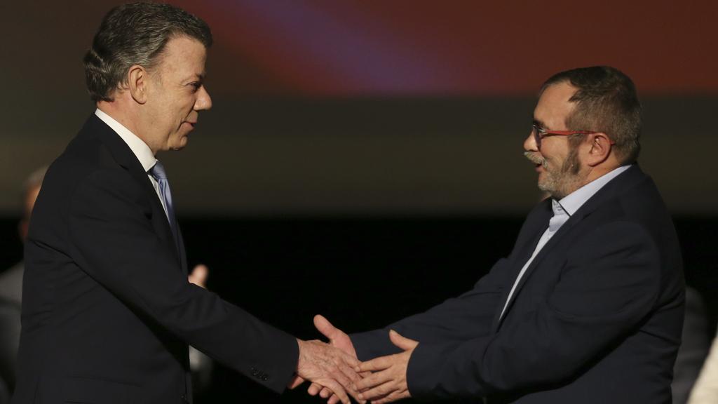 Le président colombien Juan Manuel Santos et le chef des FARC Rodrigo Londono se serrent la main après la signature de l'accord de paix.