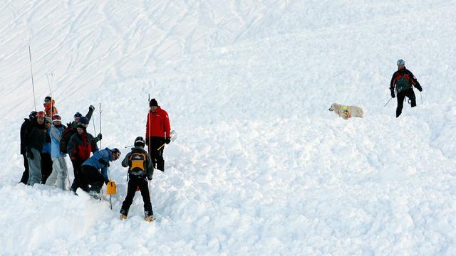 Des secouristes au travail après l'avalanche qui avait dévalé sur une piste balisée à Anzère le 29 décembre 2009. [Keystone - Jean-Christophe Bott]