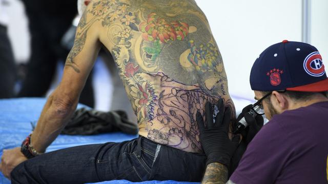 Un artiste tatoue un visiteur lors de la seconde édition du Montreux Tattoo Convention, le samedi 17 septembre 2016. [KEYSTONE - Laurent Gillieron]