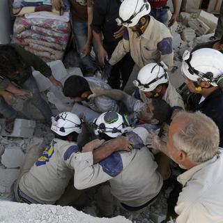 La protection civile syrienne, appelée aussi les "casques blancs", intervient pour extraire les survivants des gravats après les bombardements. [Reuters - Khalil Ashawi]