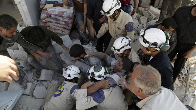 La protection civile syrienne, appelée aussi les "casques blancs", intervient pour extraire les survivants des gravats après les bombardements. [Reuters - Khalil Ashawi]