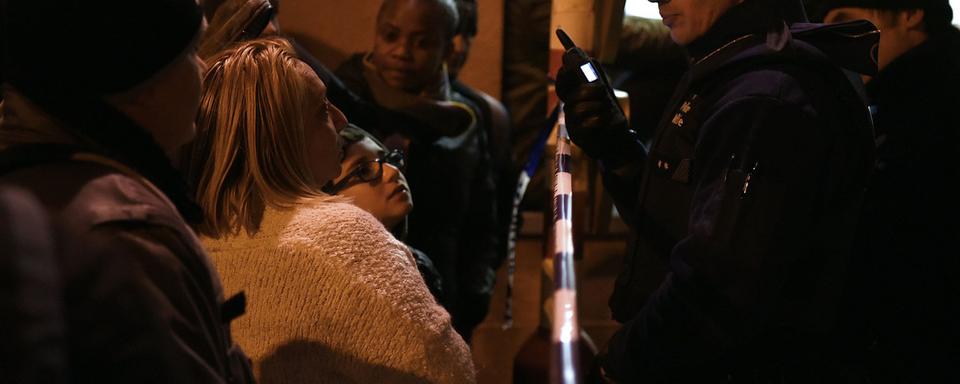 Des policiers discutent avec des habitants de Schaerbeek mardi soir. [AFP - Patrik Stollarz]