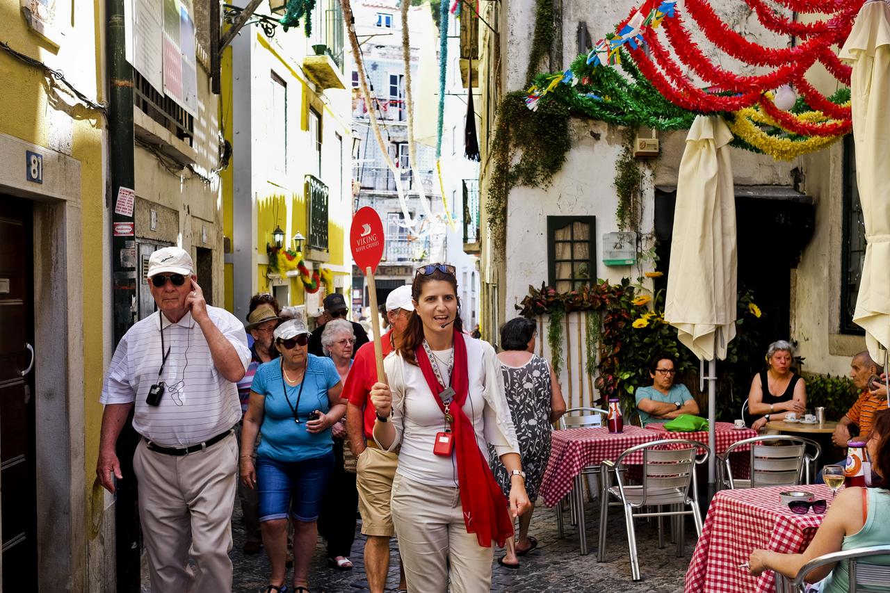 Un guide touristique avec son groupe dans les ruelles d'Alfama, le 2 juillet 2016. [AFP - PATRICIA DE MELO MOREIRA]