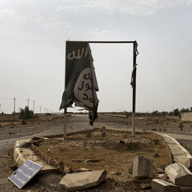 Un drapeau du groupe Etat islamique en lambeaux à l'entrée de la ville de Qayara, en Irak. [AP Photo/Keystone - Susannah George]