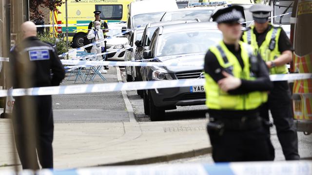 Des officiers de police derrière un cordon de sécurité à Birstall près de Leeds. [Craig Brough]