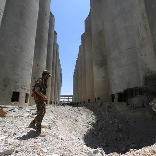 Un combattant des Forces démocratiques syriennes dans les ruines des moulins de Manbij en Syrie. [Reuters - Rodi Said]