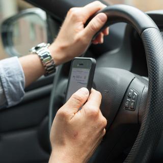 L'usage du smartphone pour envoyer des SMS sur la route est une pratique dangereuse. [S. Engels]