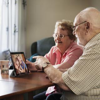 Un coupe de personnes âgés en train de chatter en vidéo. [AFP / Cultura Creative - Jason Butcher]