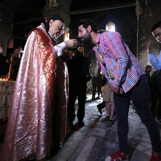 L'archevêque de Mossoul donne la communion à Qaraqosh (Irak) le 30 octobre 2016.