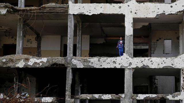 Lundi 22 février: Une jeune Palestinienne se tient dans un appartement partiellement détruit dans la guerre entre Israël et le Hamas dans la bande de Gaza. [AP Photo/Hatem Moussa]