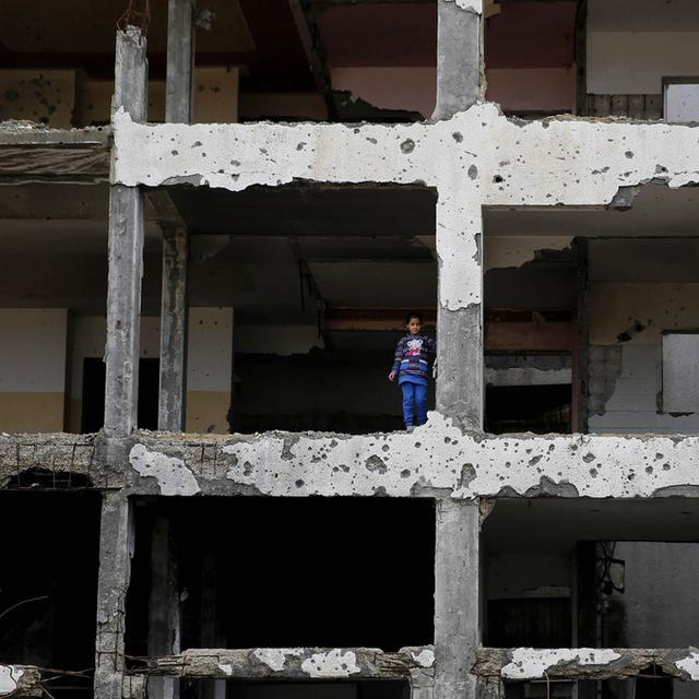 Lundi 22 février: Une jeune Palestinienne se tient dans un appartement partiellement détruit dans la guerre entre Israël et le Hamas dans la bande de Gaza. [AP Photo/Hatem Moussa]