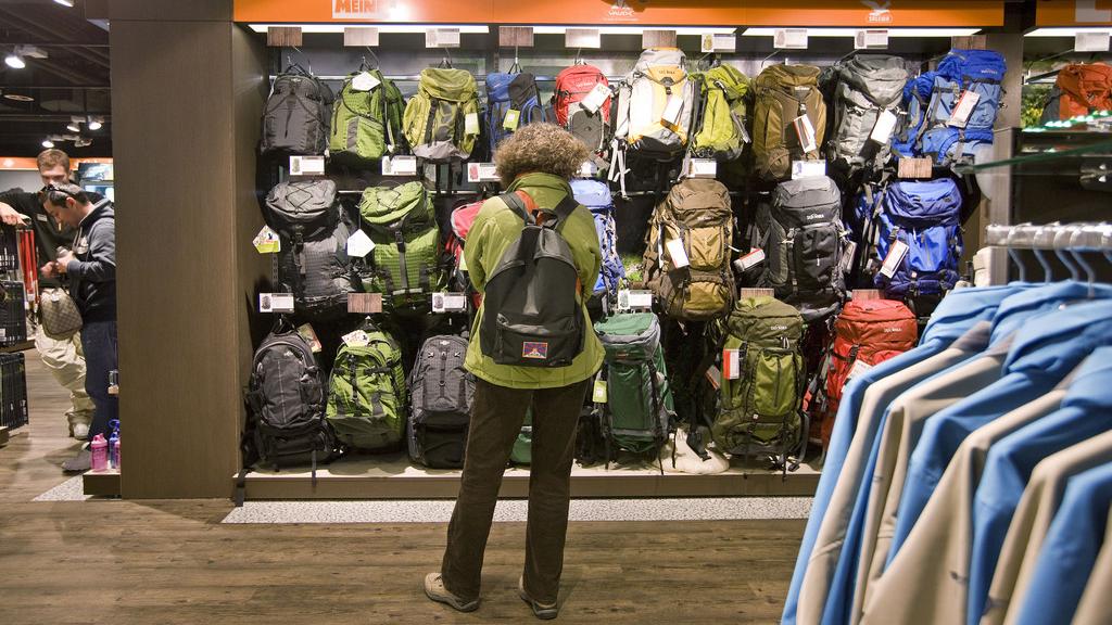 Une cliente observe les sacs à dos dans un magasin de sport à Zurich. [Keystone - Alessandro Della Bella]