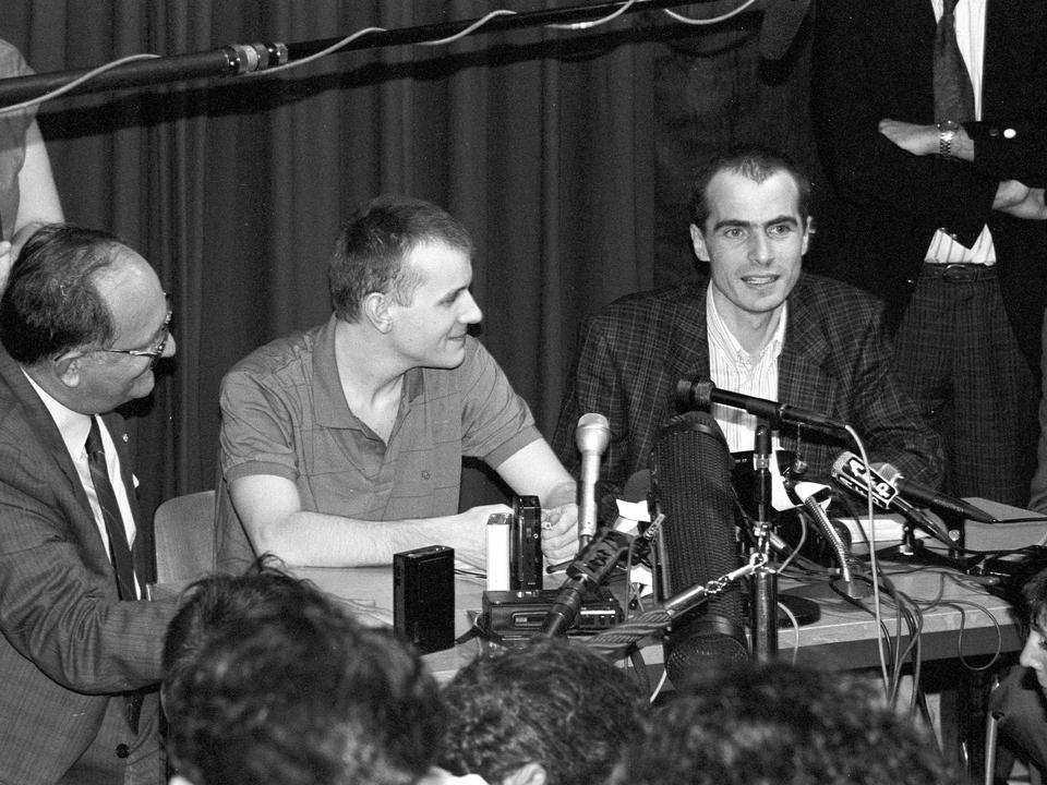 Le président du CICR Cornelio Sommaruga avec Elio Erriquez et Emanuel Christen, deux collaborateurs libérés après dix mois de détention au Liban, 14 août 1990. [CICR]
