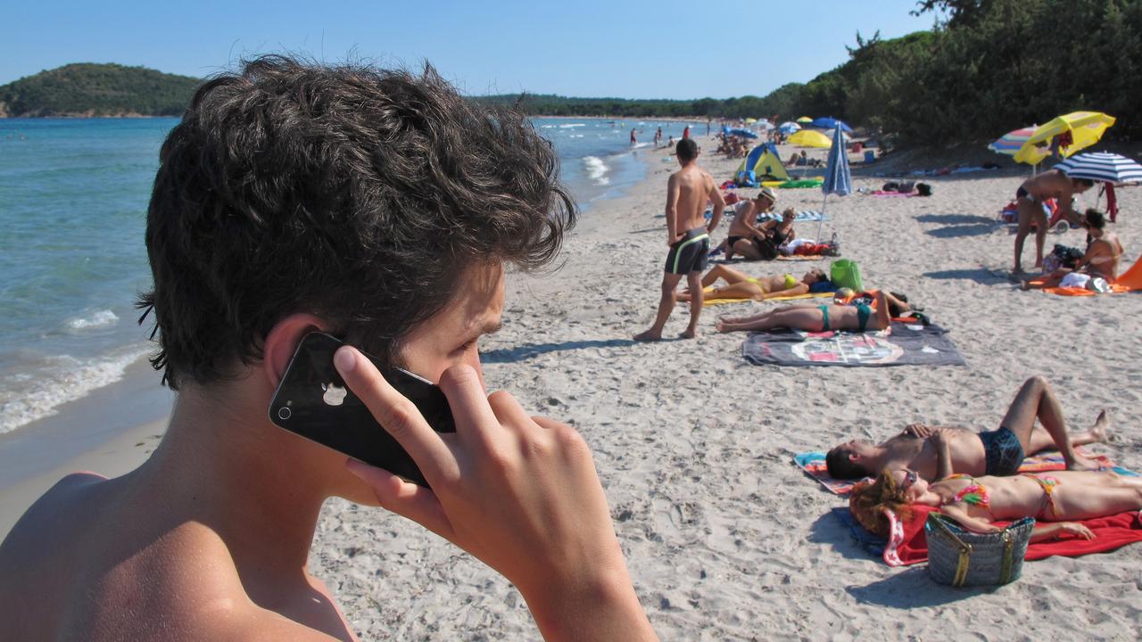 Un jeune au téléphone sur une plage en Corse. [DPA/AFP - Karl-Josef Hildebrand]
