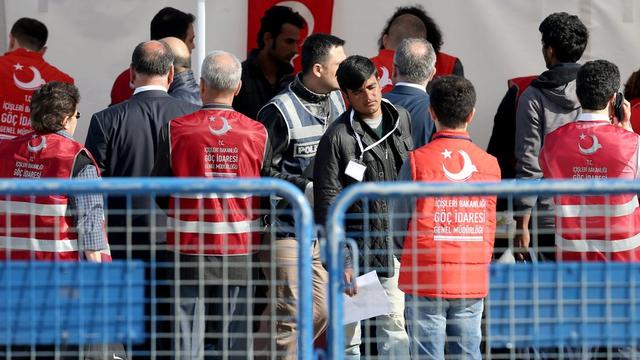 Les premiers migrants renvoyés en Turquie lors de leur arrivée à Izmir. [EPA/Keystone - Tolga Bozoglu]