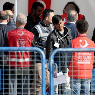 Les premiers migrants renvoyés en Turquie lors de leur arrivée à Izmir. [EPA/Keystone - Tolga Bozoglu]