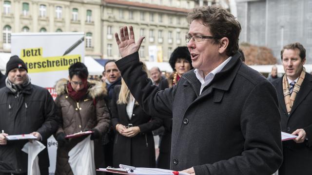 Le président de l'UDC Albert Rösti lance la récolte de signatures à Berne. [Keystone - Anthony Anex]