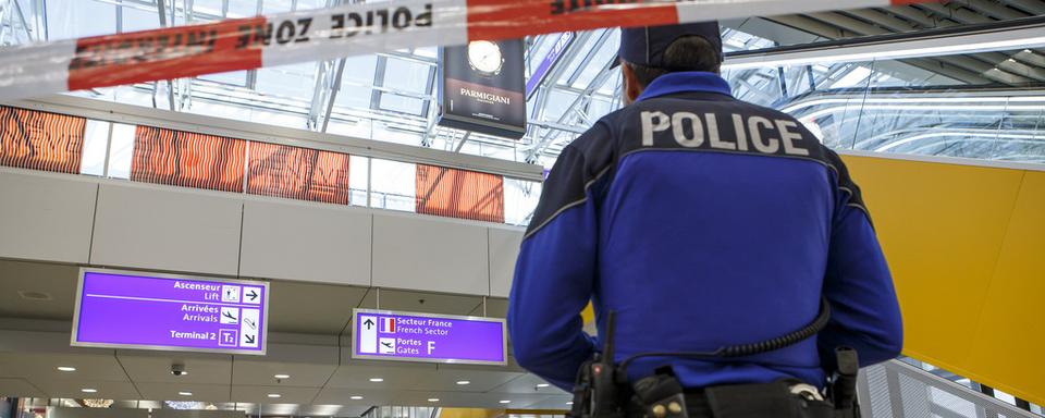 Un policier genevois lors d'une alerte à l'aéroport international de Genève. [Keystone - Salvatore Di Nolfi]