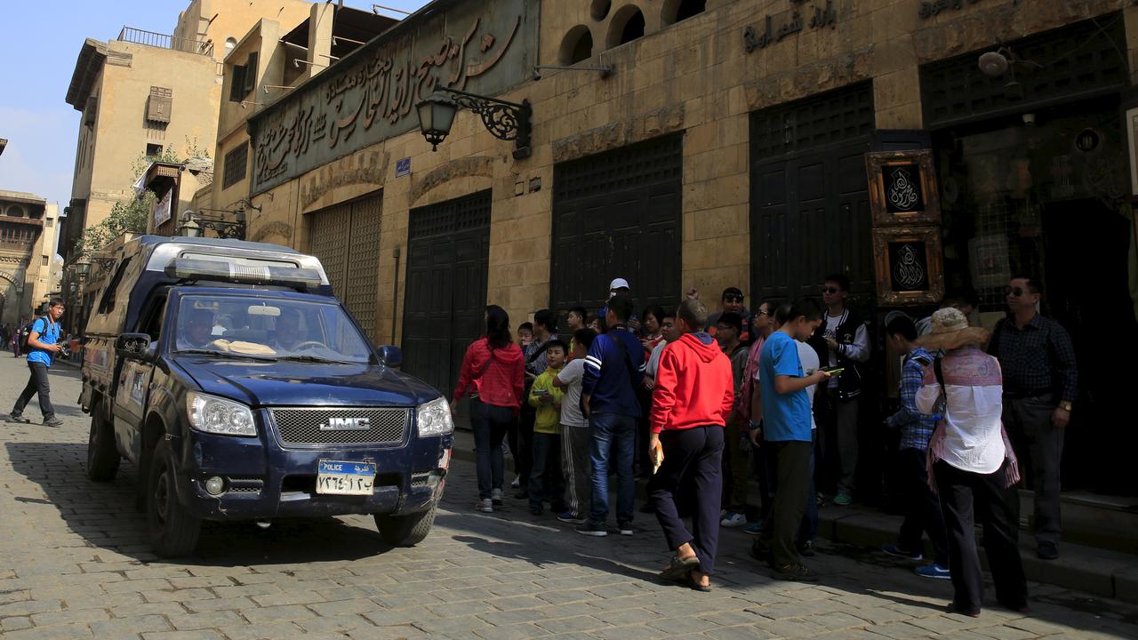 Une voiture de patrouille passe devant des touristes au Caire. [Amr Abdallah Dalsh]