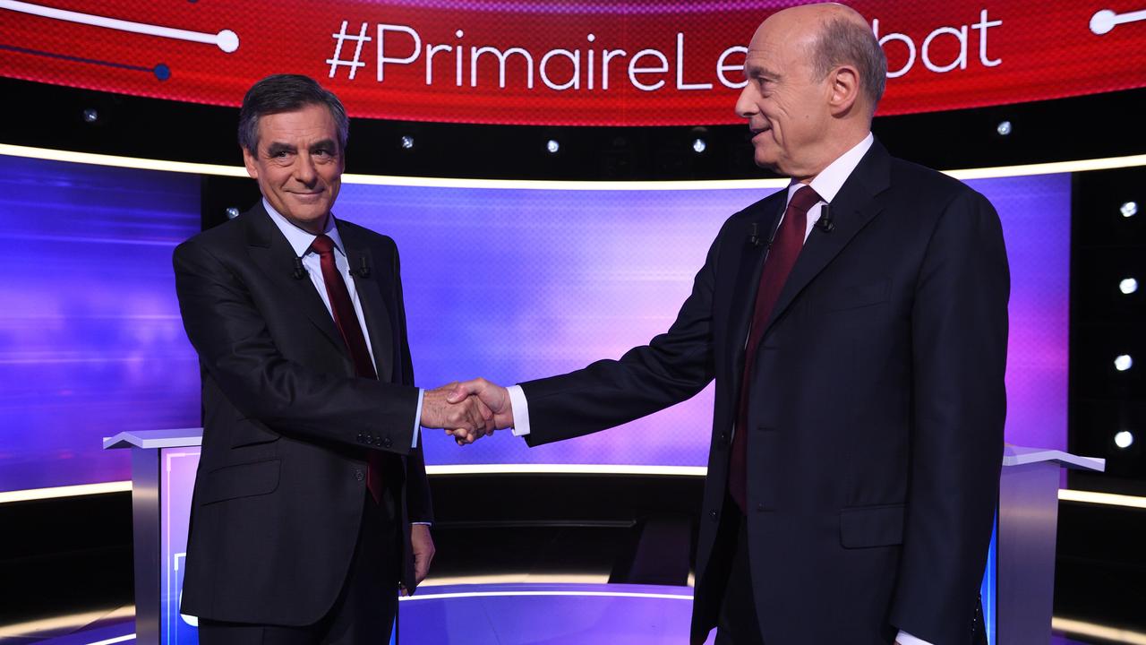 François Fillon et Alain Juppé se serrent la main après le débat pour le second tour de la primaire de la droite et du centre. [AFP - Eric Feferberg]