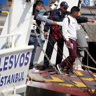 Des migrants arrivés de l'île grecque de Lesbos sur le port turc de Dikili. [Emre Tazegul]