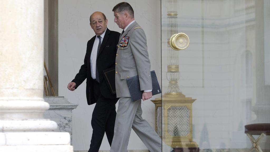 Le ministre français de la Défense, Jean-Yves Le Drian, en discussion avec Benoit Puga, chef d'Etat-major particulier de François Hollande. [AP Photo - Jacques Brinon]